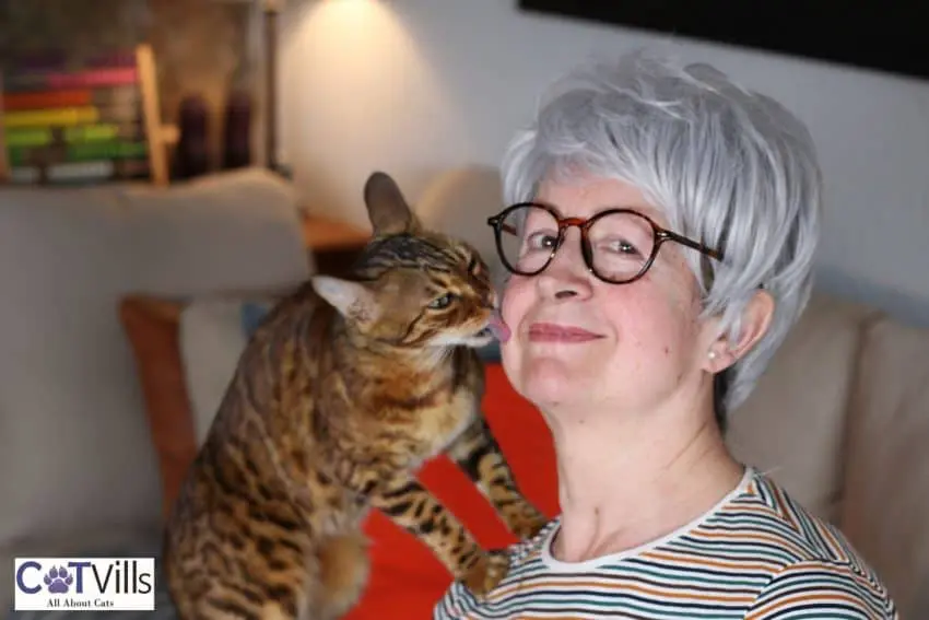 cat licking the woman's face thinking "why does my cat lick my nose?"