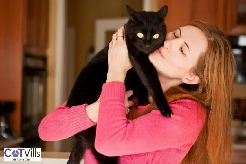 lady kissing her black cat