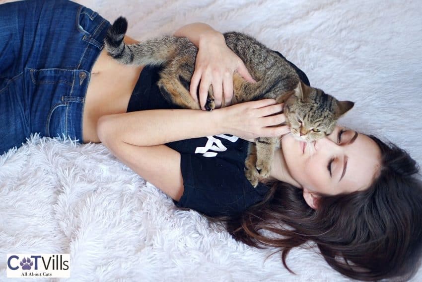 lady cuddling with her cat on the bed
