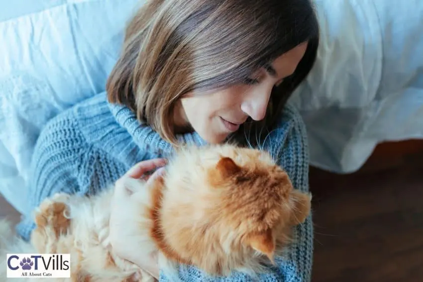 lady hugging her orange cat