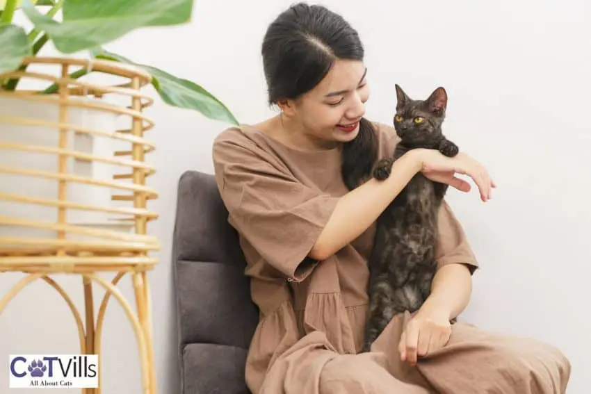 pregnant woman carrying her black cat